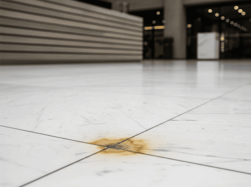 Flek kuning kecokelatan pada permukaan marmer