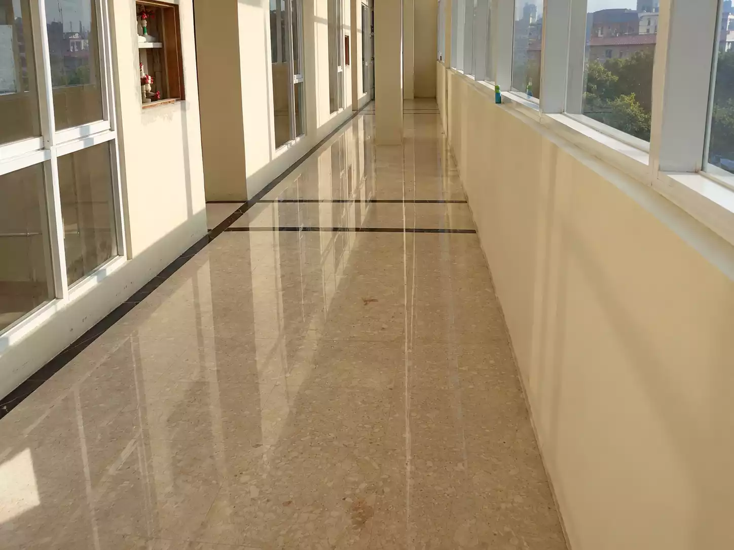 Hasil poles lantai marmer mengilap di koridor gedung oleh Nusantara Cleaning Bandung.